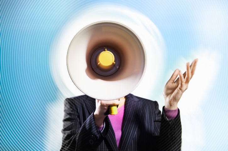 person holding megaphone against blue background