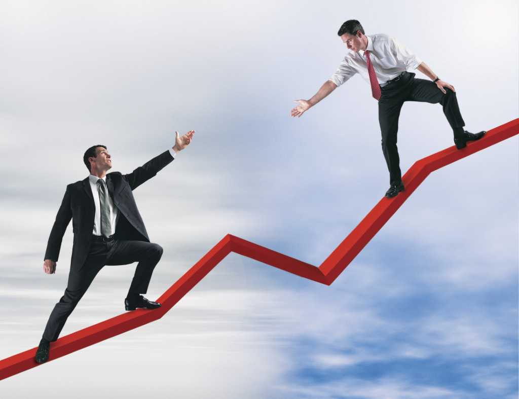2 male executive standing on fever line reaching out to each other showing partnership or mentoring