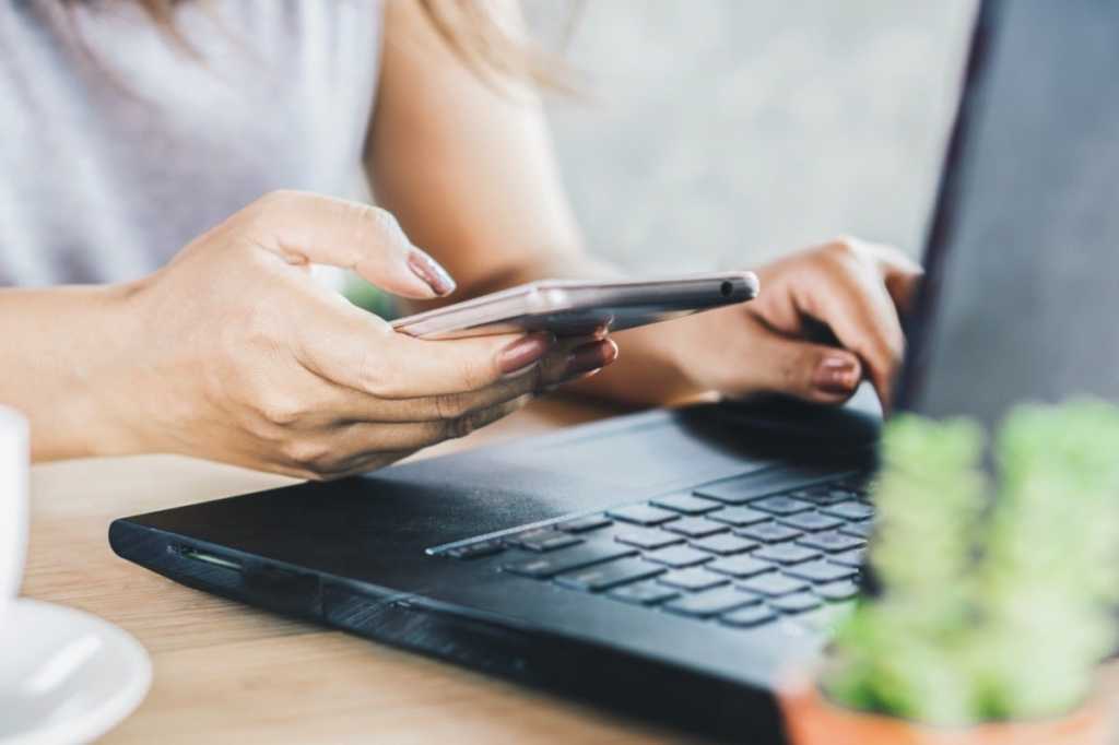 woman hand using smart phone and typing on keyboard of computer at picture id1157961017