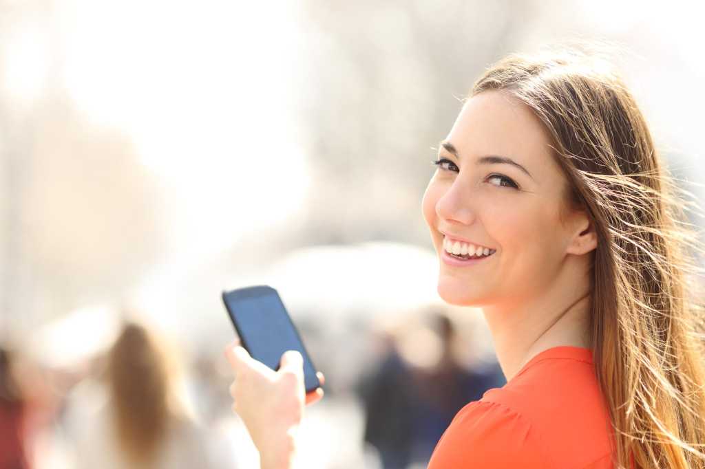 young women smiling smartphone mobile device millenials