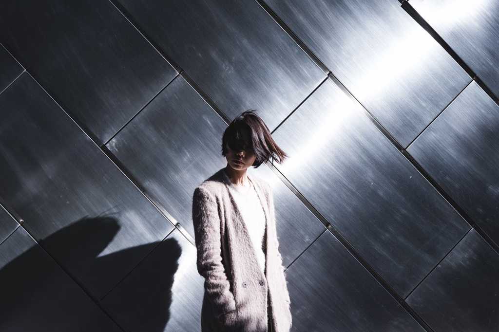 a woman stands in light and shadow / Tokyo, Japan