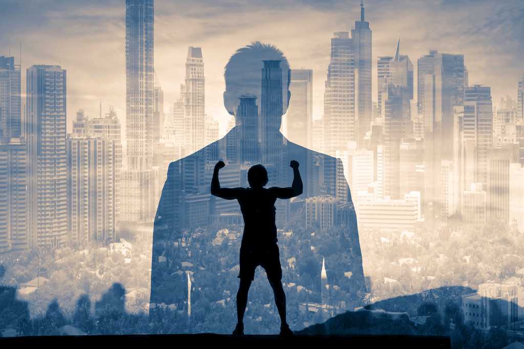 Double-exposure of a city and a businessman's silhouette containing the shadow of a strongman.