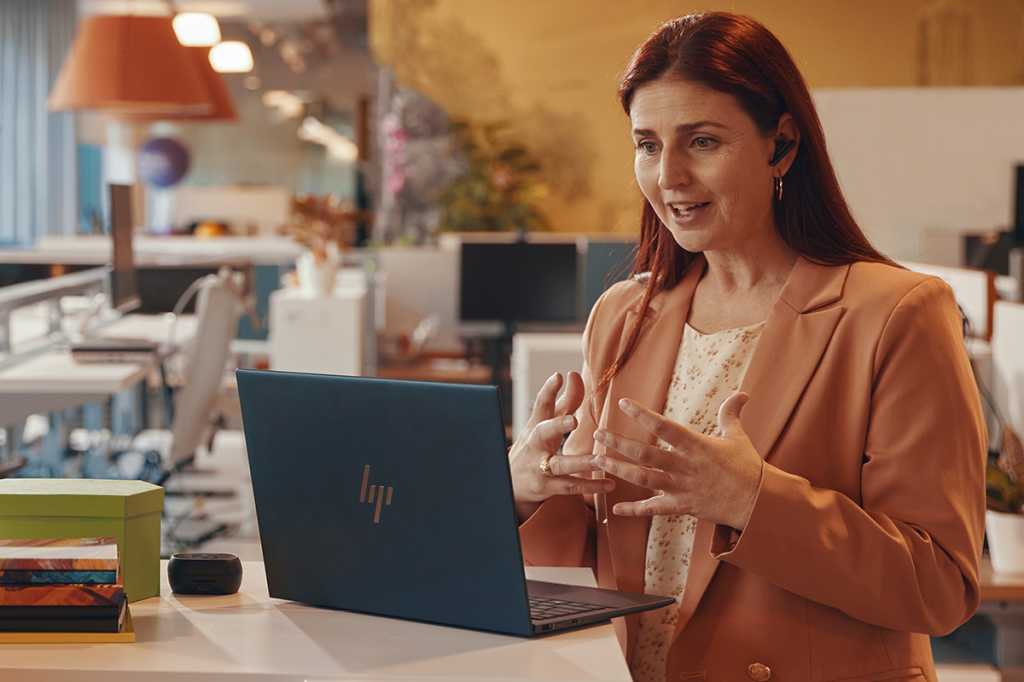 Image of business women standing in front of her laptop on a conference call