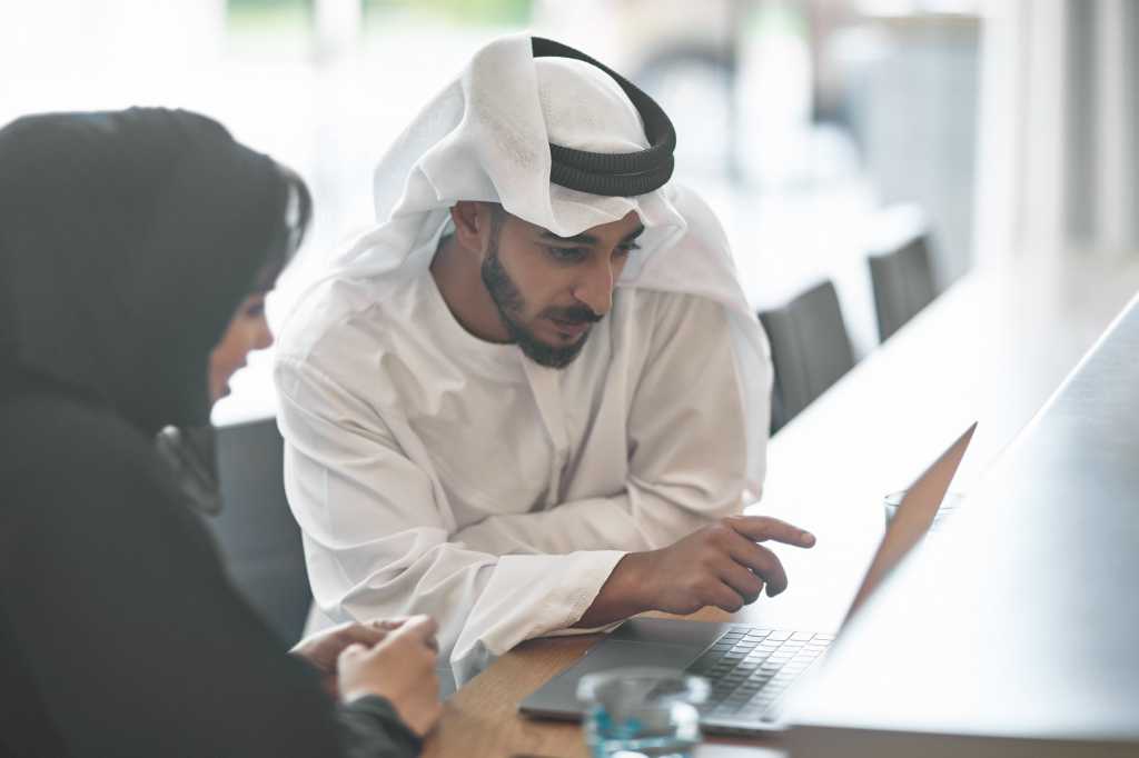 diversity saudi arabian man and woman laptop collaboration uae middle east saudi arabia by xavierar