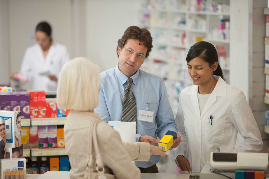 Pharmacists answering questions for customer in drug store
