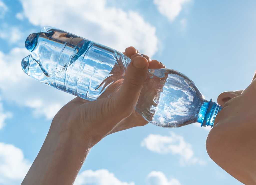 person drinking bottled water