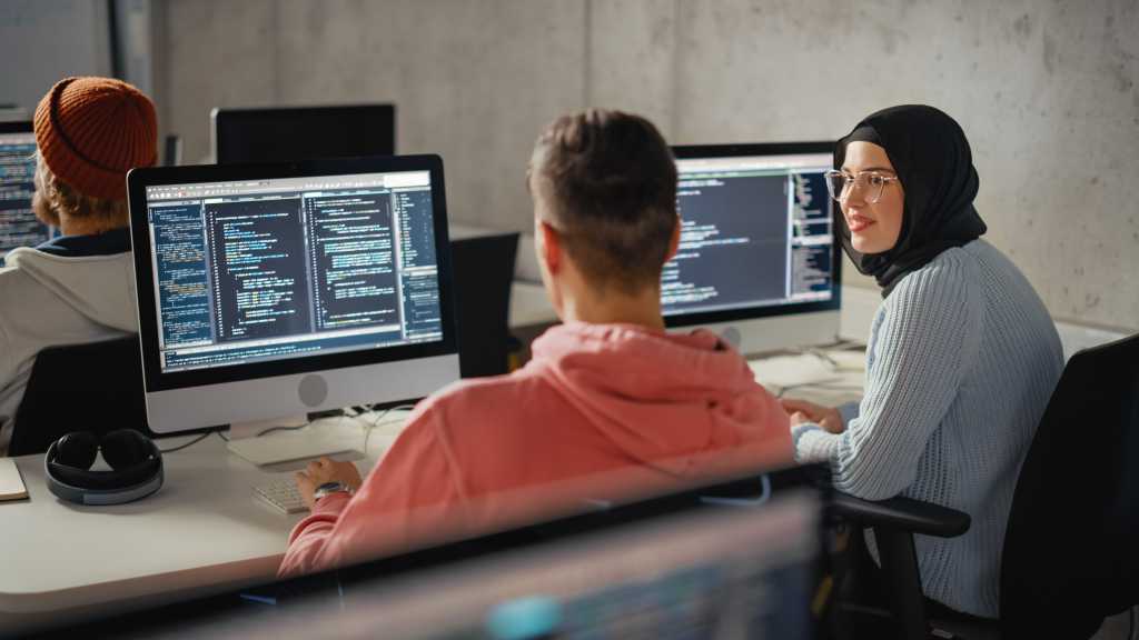 Smart Young Students Studying in University with Diverse Multiethnic Classmates. Scholars Collaborate in College Room on Computer Science Project, Writing Software Code in Successful Teamwork.