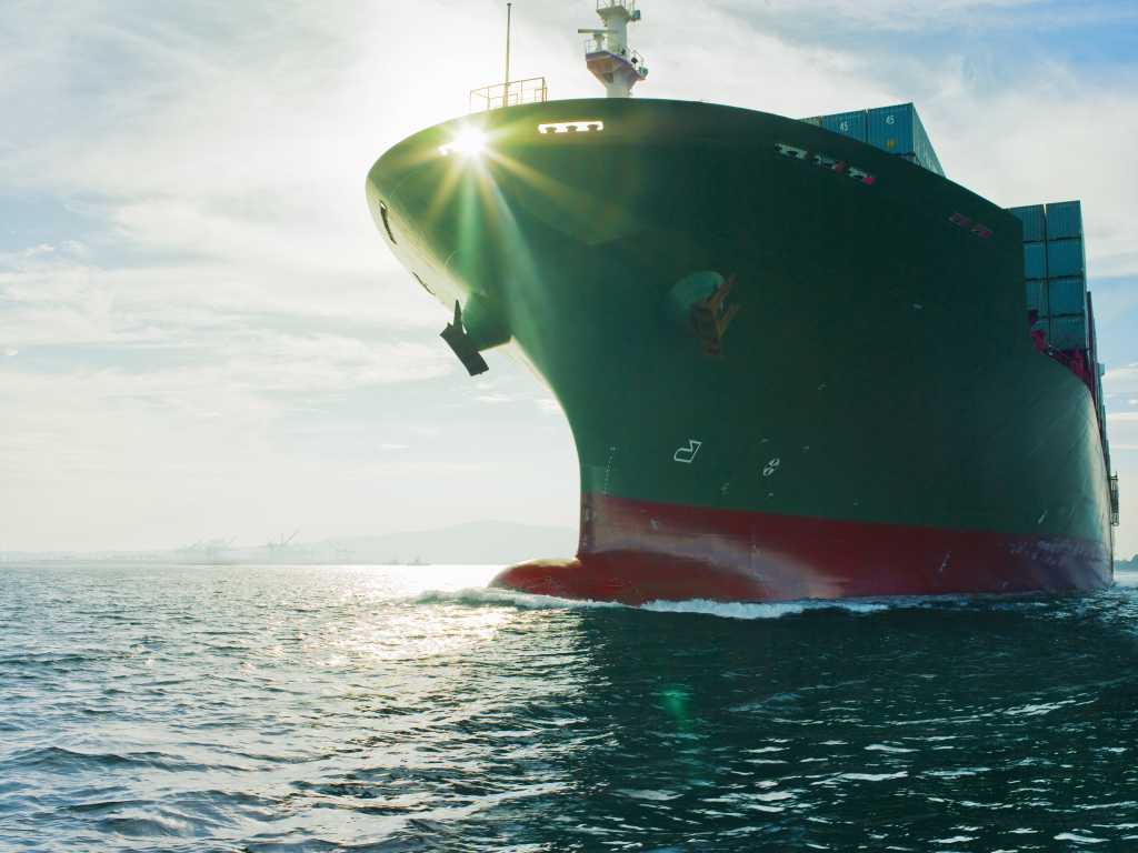 sun shining through bow of cargo ship 84039583