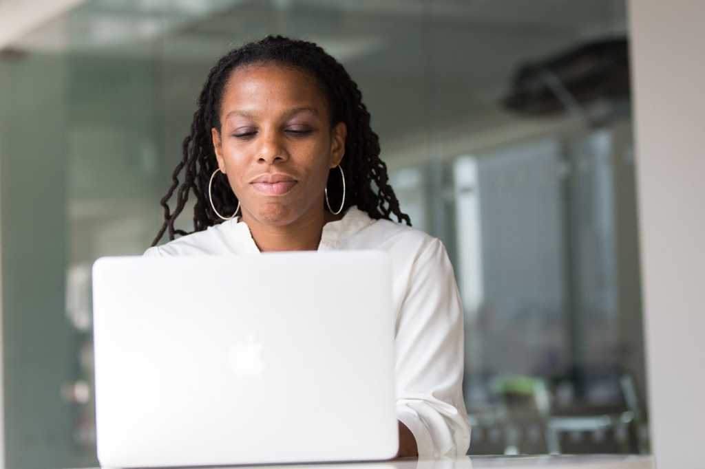 african american woman on laptop mac diversity gender equality programmer devops by christina moril