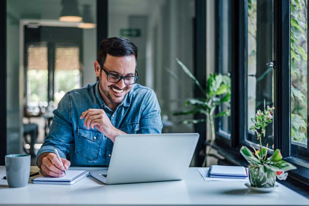 man looking at laptop smiling