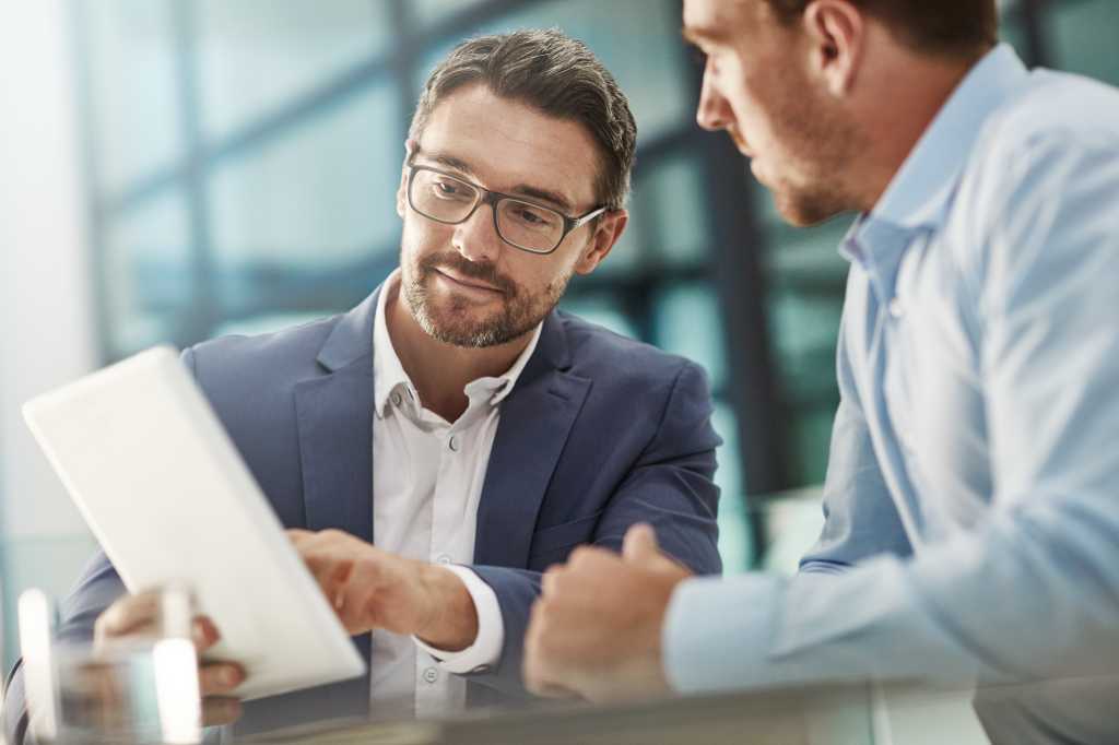 Tablet, teamwork and meeting of business people in office discussion. Collaboration, technology and men or employees with touchscreen planning sales, marketing or advertising strategy in company.
