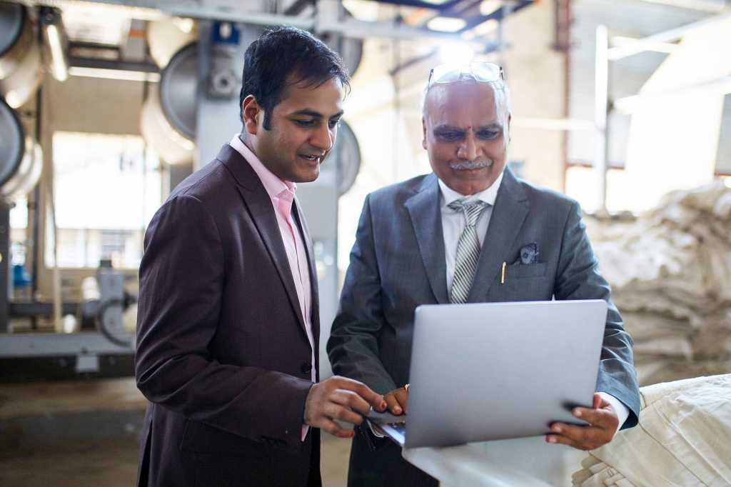 Industrial IoT / Operational Technology  >  Indian businessmen meet on a factory floor.