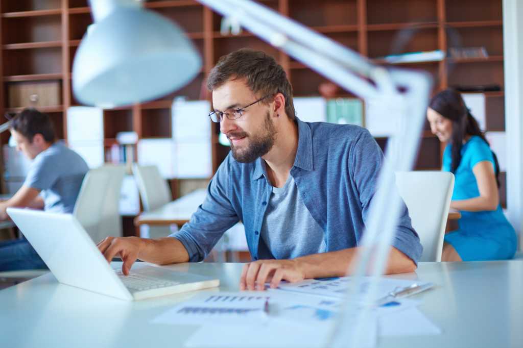 Man in office working on PC laptop