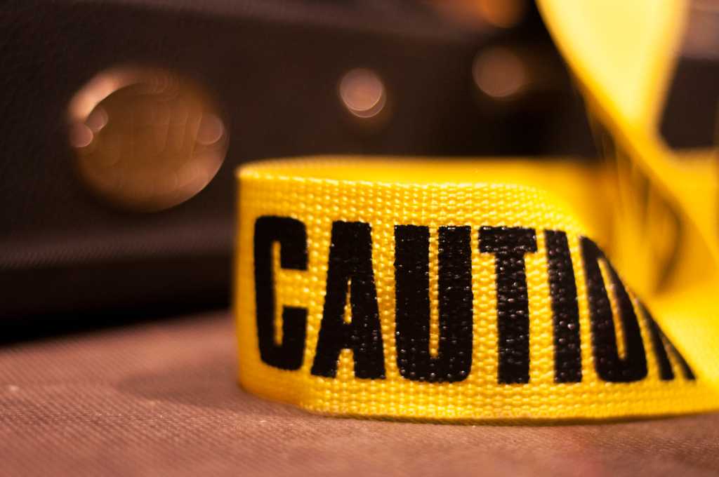A yellow guitar strap on stage whit the word caution on it