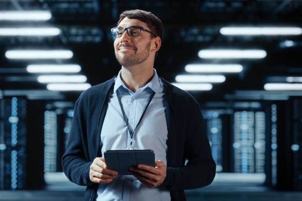 male it specialist walks between row of operational server racks in picture id1394184350