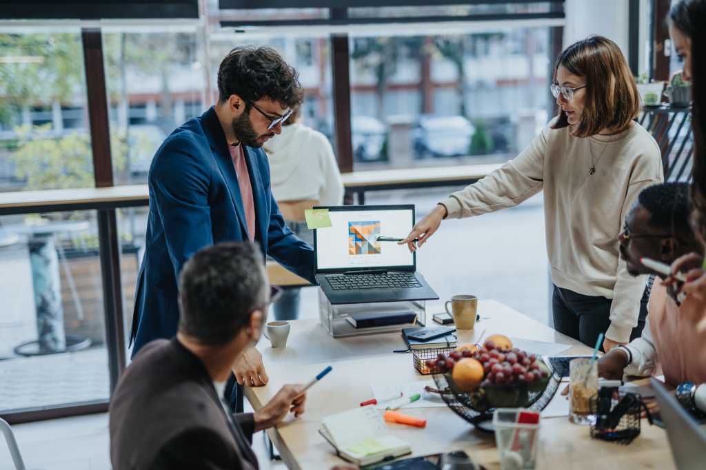 A diverse group of professionals collaborate in a modern office, discussing market research, strategic planning, and sustainable business expansion.