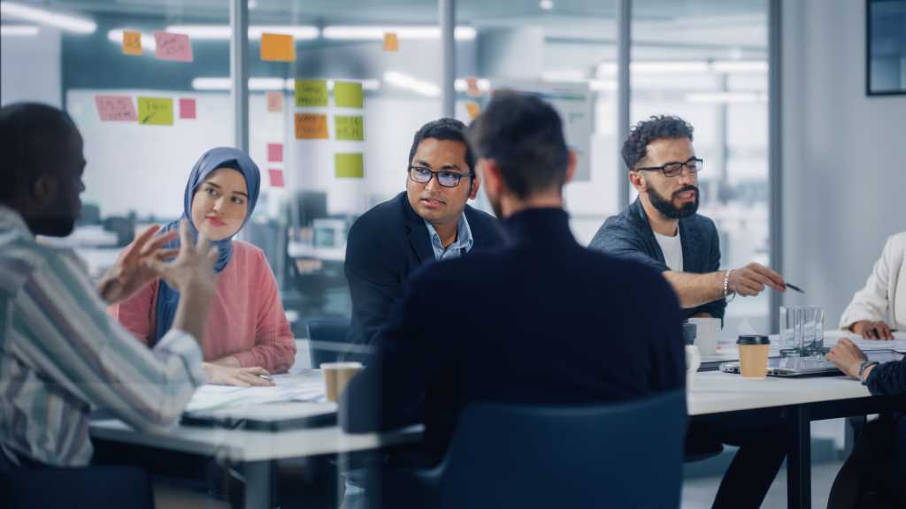 Multi-Ethnic Office Conference Room Meeting: Diverse Team of Creative Entrepreneurs, Specialists Talk, Use TV for infographics. Businesspeople work on Digital e-Commerce Startup.
