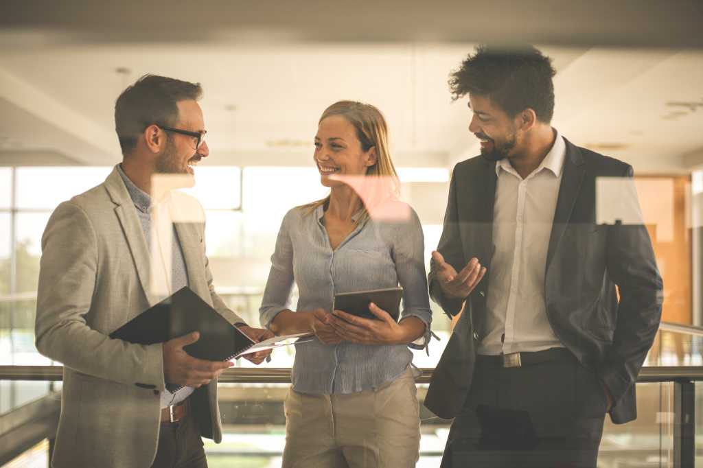 Business people in office having conversation and using technology.