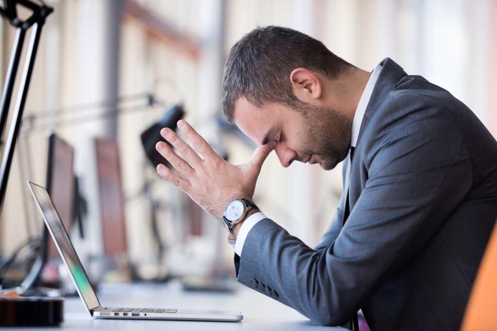 frustrated young business man working on laptop computer at office