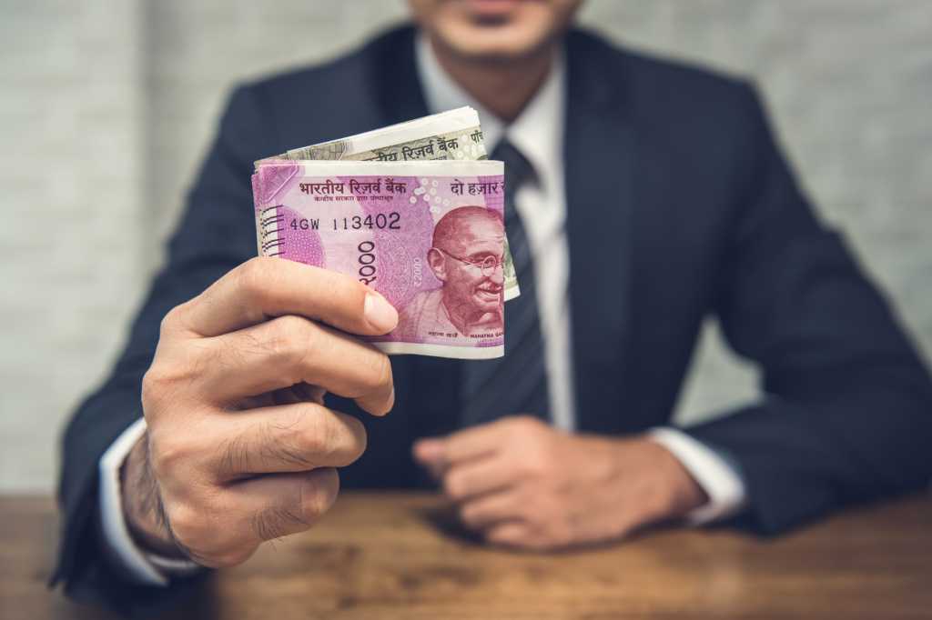 indian money held by man in suit currency rupee bank notes by kritchanut gettyimages 950701812