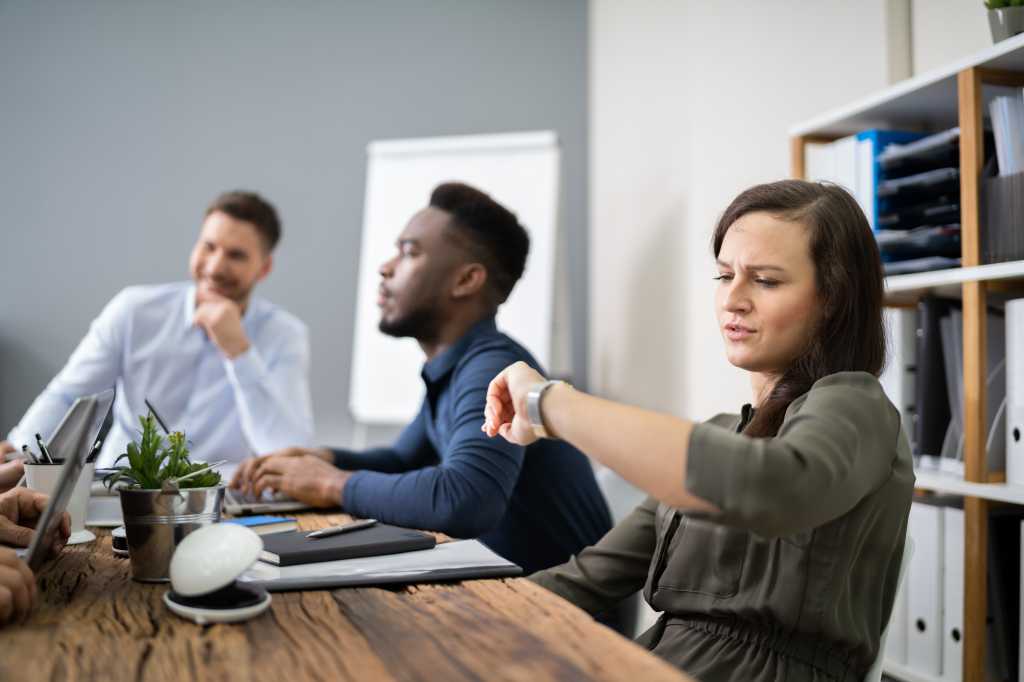 Woman Checking Time While Sitting In A Boring Long Meeting
