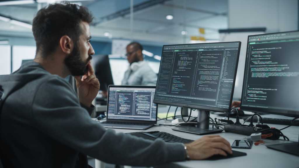 Diverse Office: Enthusiastic White IT Programmer Working on Desktop Computer. Male Specialist Creating Innovative Software. Engineer Developing App, Program, Video Game. Writing Code in Terminal