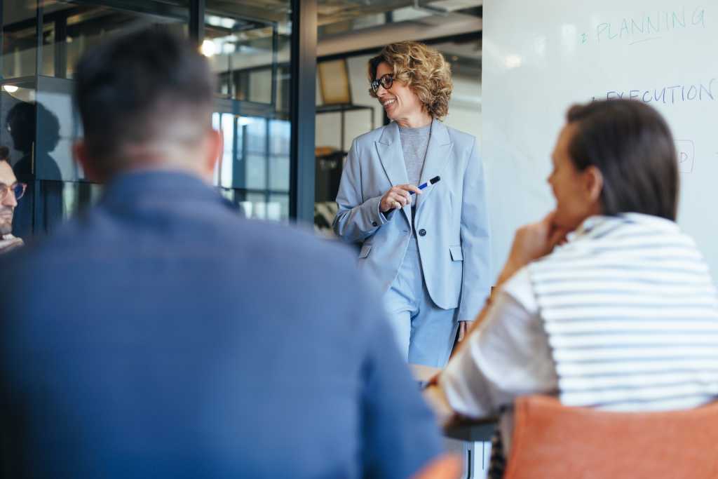Business colleagues having a discussion in a presentation. Team of business professionals having a meeting in an office. Group of business people working together on a project.