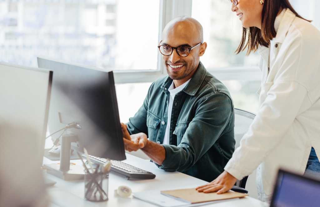 Man and woman coworkers looking at computer screen