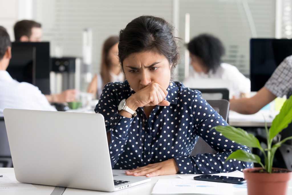 Focused worried Indian businesswoman looking at laptop screen, doubting, thinking of difficult question or task, female employee upset by receiving bad news, tired office worker have too much work