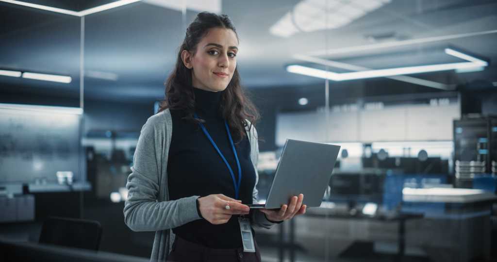 Portrait of a Happy Smiling Female, Using Laptop Computer, Looking at Camera and Smiling. Empowered Information Technology Specialist, Software Engineer or Developer