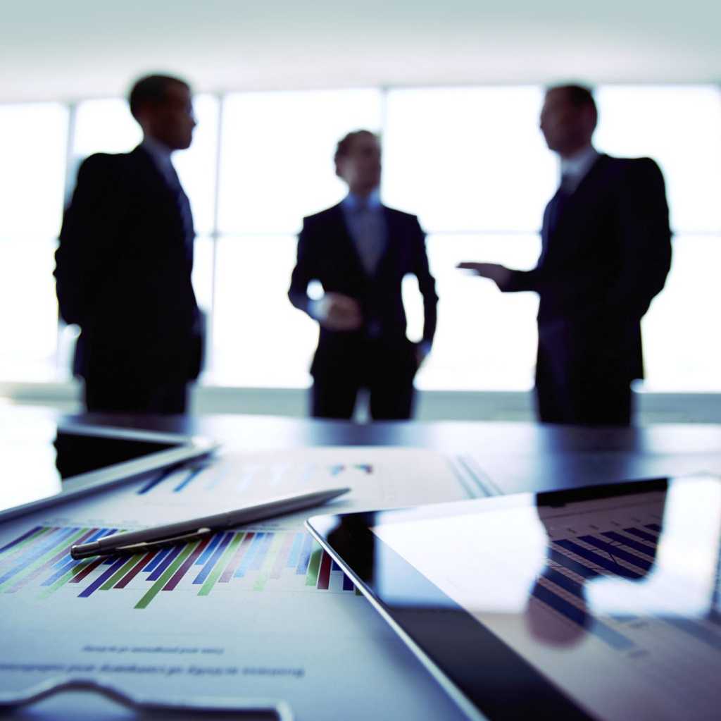 Business meeting with tablet screens showing data and graphs.