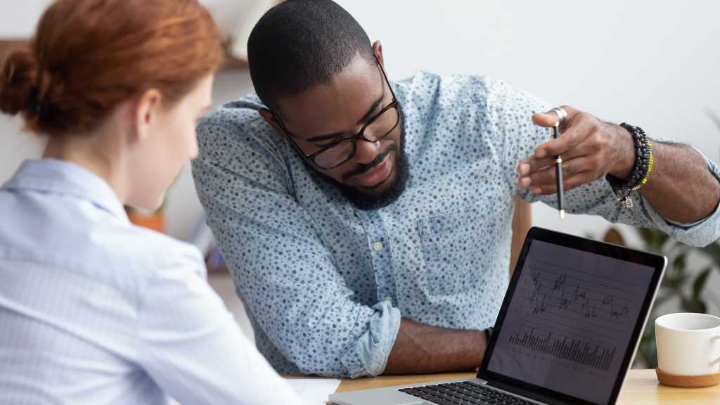 colleagues discussing data on a laptop
