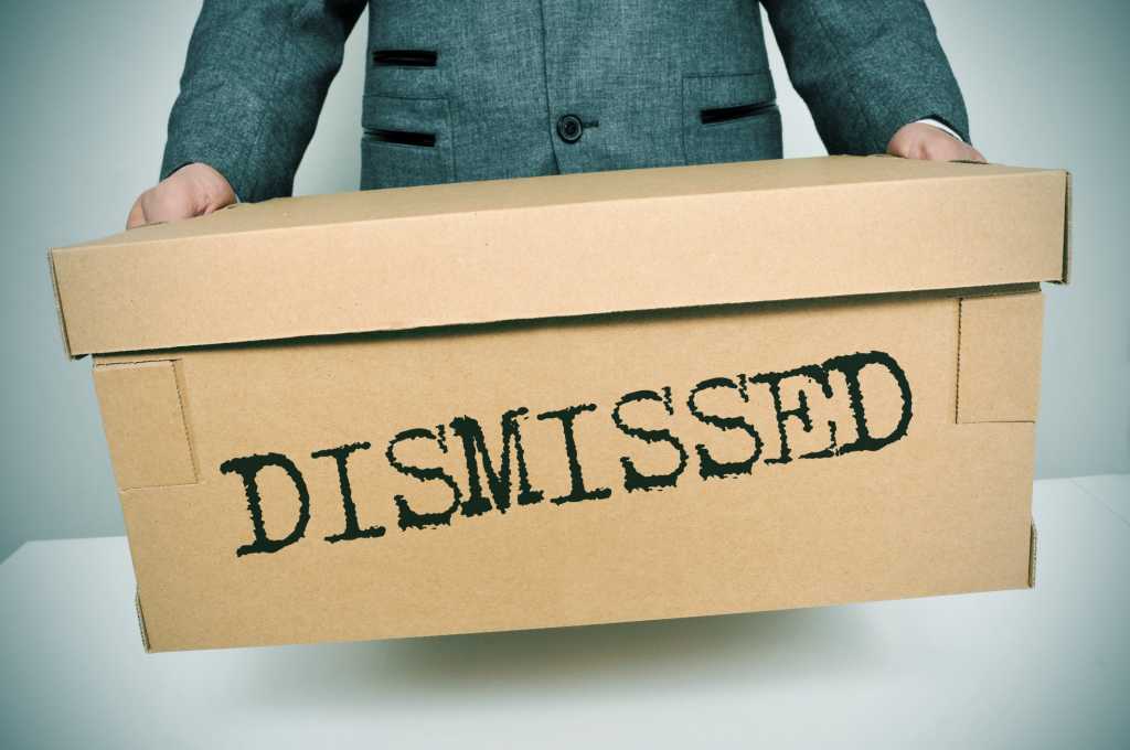 man holding box of personal items after being fired from job