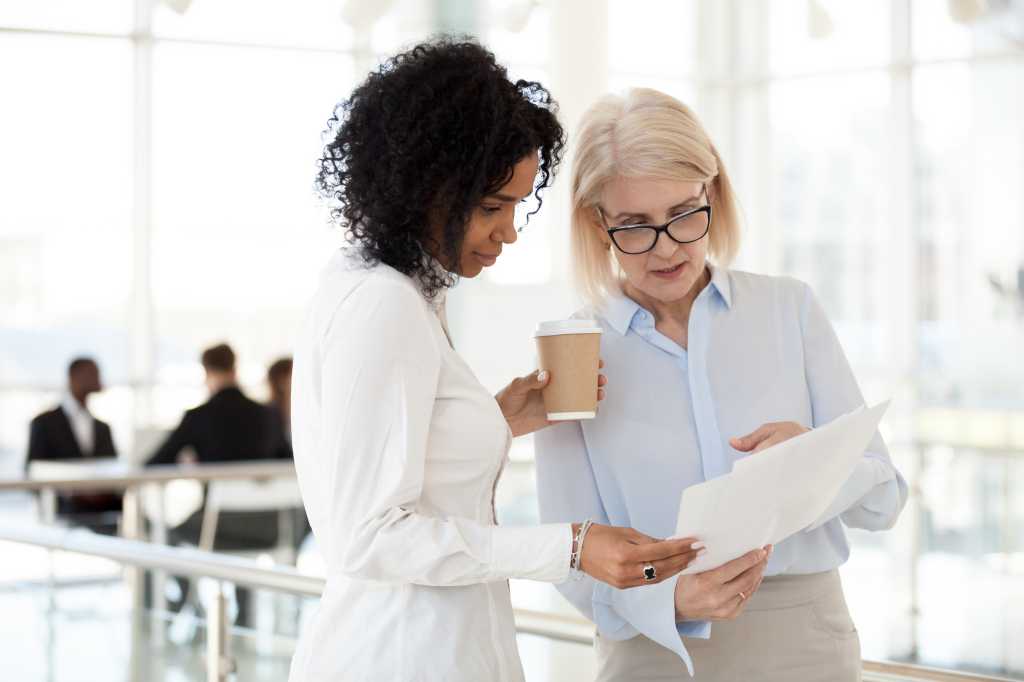 Senior mature female executive mentoring young colleague
