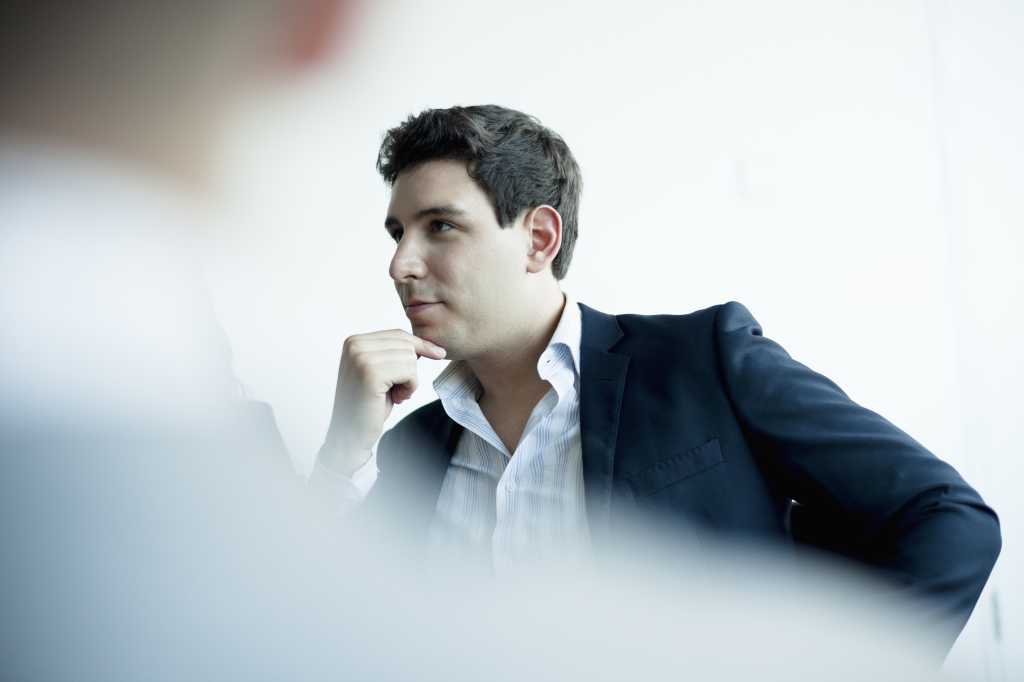 Young businessman listening in business meeting