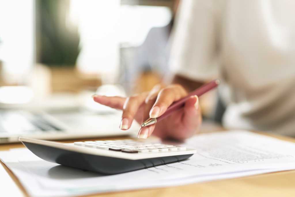 Shot of a businesswoman using a calculator to budget her finances stock photo