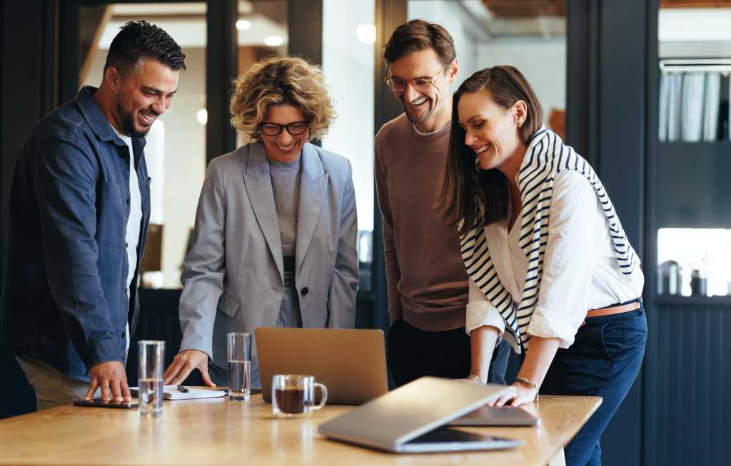Successful business team connecting with their clients on a video call. Happy business people having an online meeting in an office. Networking and collaboration in a creative workplace.