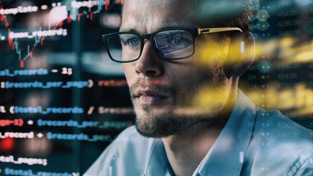 lose-up Portrait of Software Engineer Working on Computer, Line of Code Run Aroung Him. Developer Working on Innovative e-Commerce Application using Big Data Concept