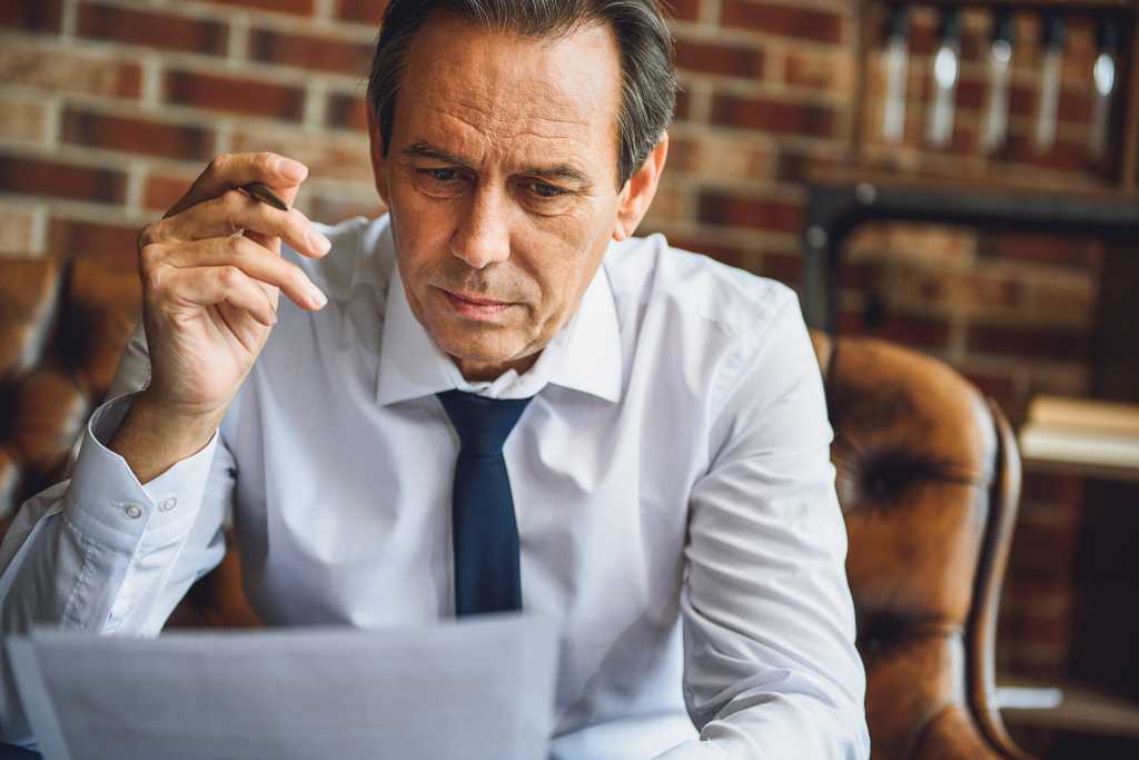 Concentrated male person looking at papers