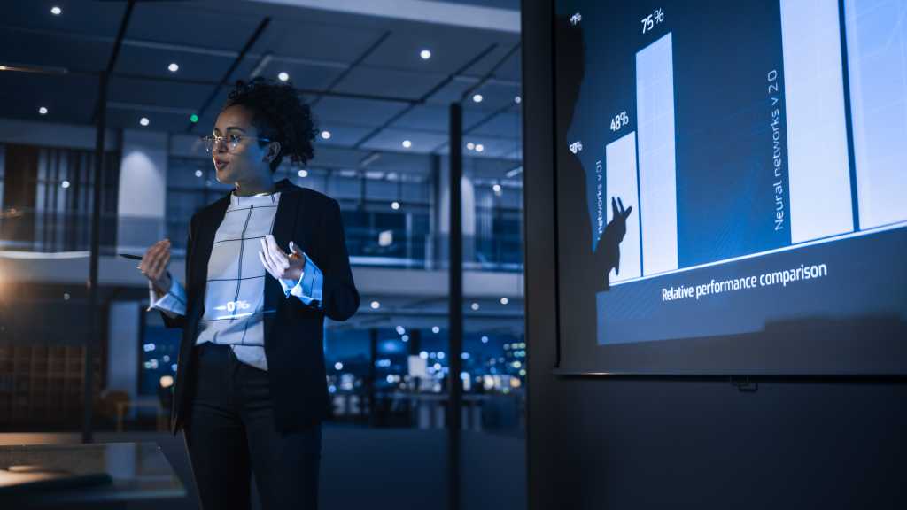 e-Business Technology Conference Presentation: Innovative Black Businesswoman Talks about Revolutionary High-Tech Product. Projector Screen Shows Graphs, Infographics, AI, Big Data, Machine Learning