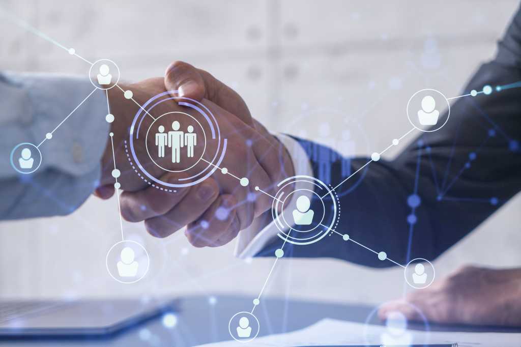 Tech recruitment concept - handshake across a virtual screen.