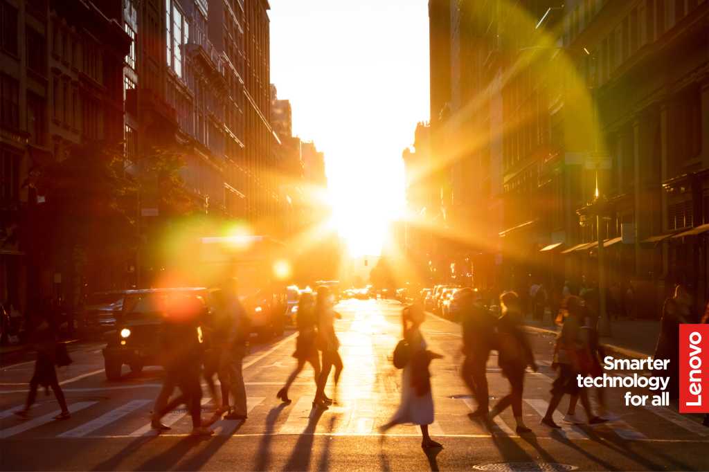 Image of people crossing the street in a city location, with a sunset behind them