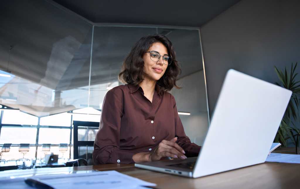 Young professional IT specialist latin hispanic lady at laptop