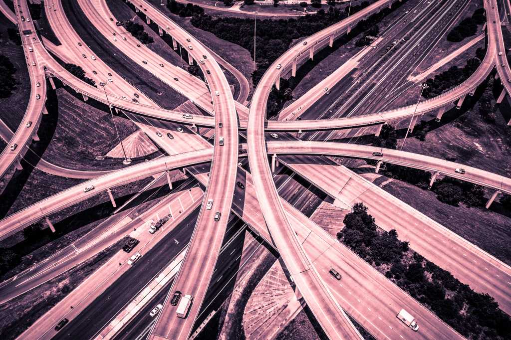 Aerial View of Curved Modern Architecture of Highways and Interchange urban sprawl abstract Drone angle red and Pink Effect