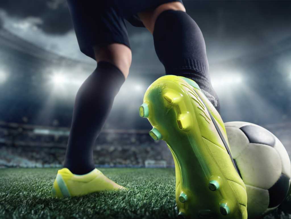 Closeup of man kicking soccer ball