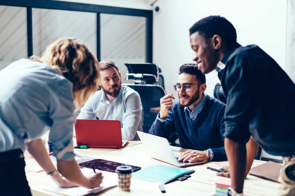 Creative team of young proud ceo experts working together on new strategy planning during meeting in office interior,group of employees discussing ideas during brainstorming briefing and collaboration